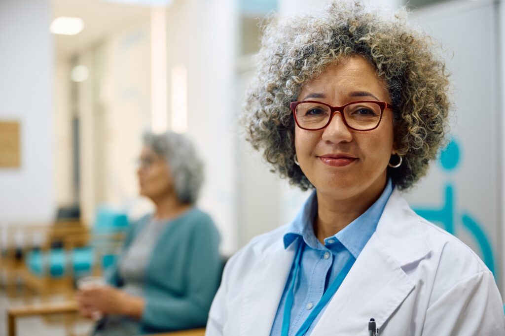 Portrait of smiling female doctor at medical clinic looking at camera.